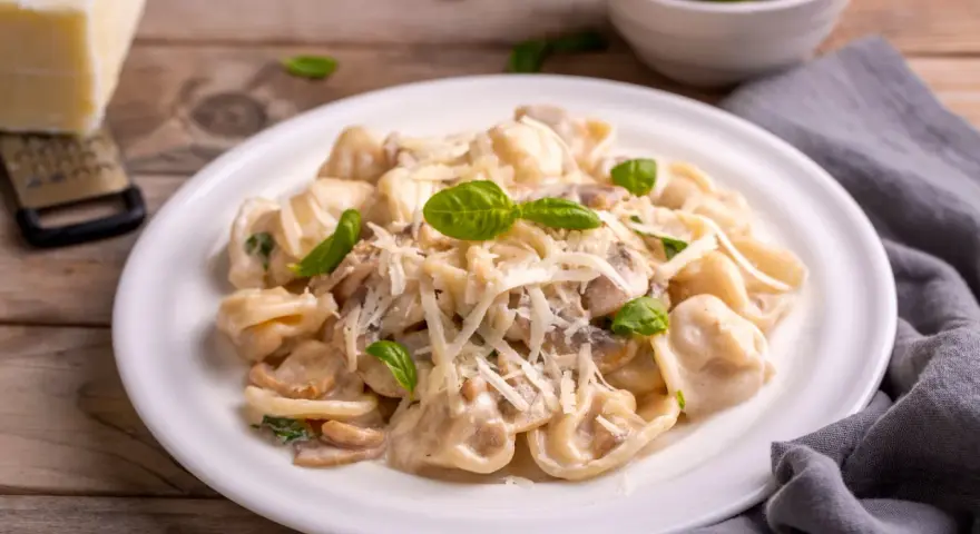 Cremige Tortellini Funghi mit frischem Basilikum und Parmesan. Ein Genuss für jeden Pasta-Liebhaber.