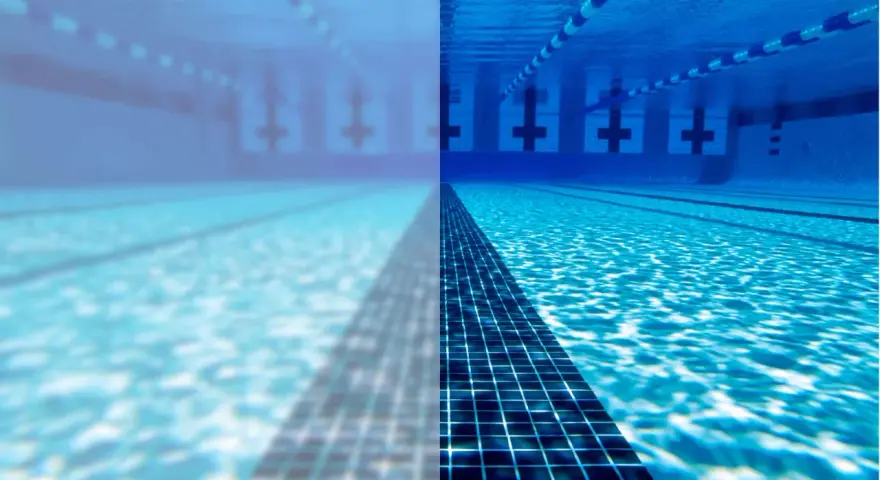 Underwater view of a swimming pool, half clear and half cloudy, with lane lines and lane markers.