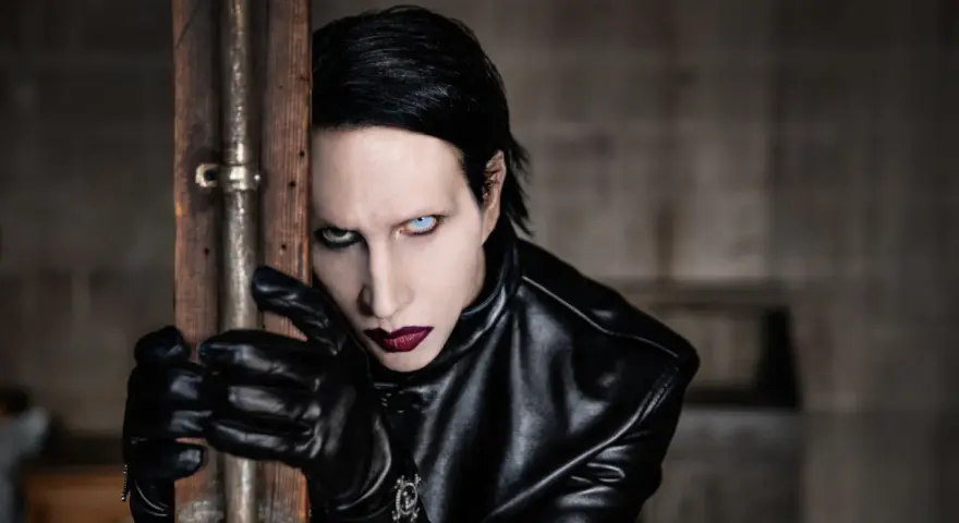 Marilyn Manson w Warszawie, w czarnej skórzanej kurtce i rękawiczkach, z charakterystycznym makijażem.