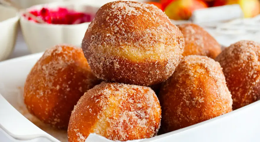 Puszyste pączki posypane cukrem z cynamonem, idealne na tłusty czwartek. Ten przepis na puszyste pączki to gwarancja sukcesu.