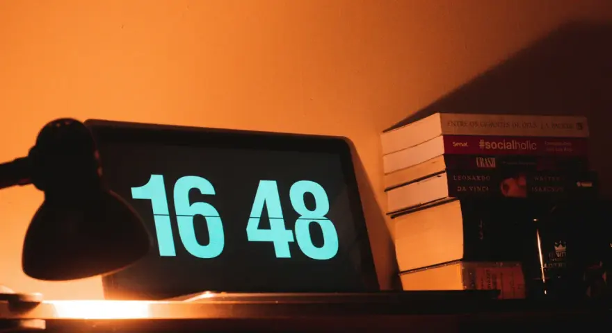 Na ekranie laptopa 16:48. Obok stos książek, w tym "#socialholic". Ile przerwy na 12 godzin pracy?