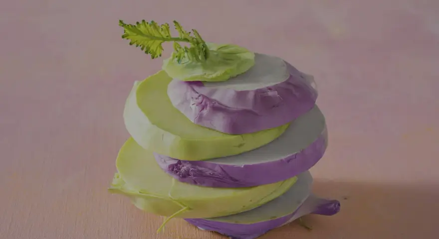 Gestapelte Scheiben von grünem und violettem Kohlrabi, bereit zum Kohlrabi kochen.