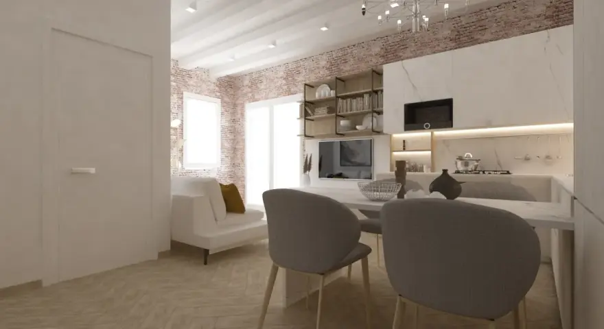 Arredare monolocale con stile: divano bianco, cucina moderna, mattoni a vista e tavolo da pranzo.