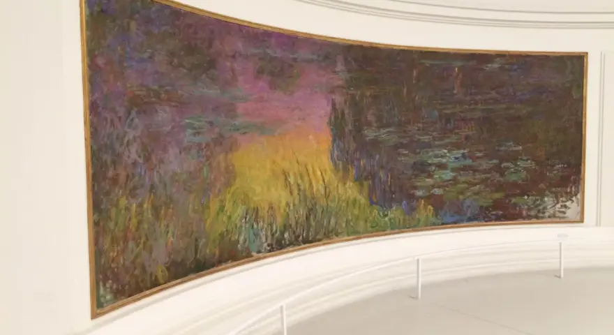 Un estanque de nenúfares con reflejos vibrantes de atardecer, una obra maestra impresionista en el **museo de la Orangerie**.