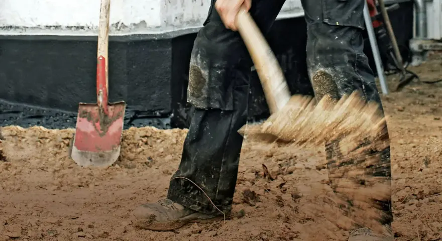 Arbetare gräver med spade, en synonym för att betona vikten av grundläggning.