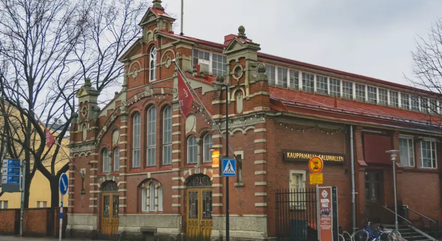 Targowisko Kauppahalli w Turku, najstarszym mieście w Finlandii, z charakterystyczną ceglaną fasadą i czerwonym dachem.