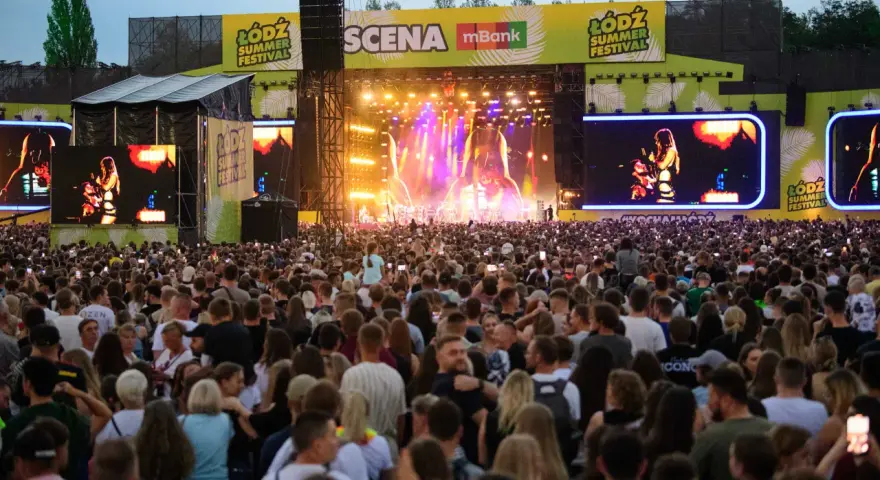 Tłum ludzi na koncercie podczas Łódź Summer Festival. Na scenie artystka, a nad nią wielkie ekrany z jej wizerunkiem.