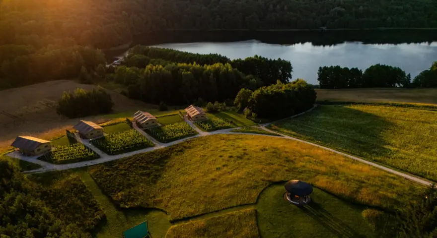 Idealne miejsce na weekend: domki w winnicy nad jeziorem, otoczone zielenią i złotym słońcem.