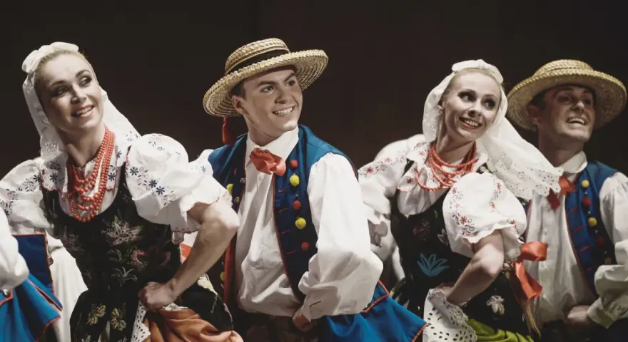 Tancerze w strojach ludowych, jakby Stanisław założył zespół Śląsk. Uśmiechnięci, w tradycyjnych strojach z haftami i koralami.