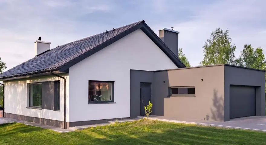 Nowoczesny dom z białymi i grafitowymi akcentami. Elewacja zewnętrzna prezentuje harmonijne połączenie kolorów, tworząc elegancki wygląd.