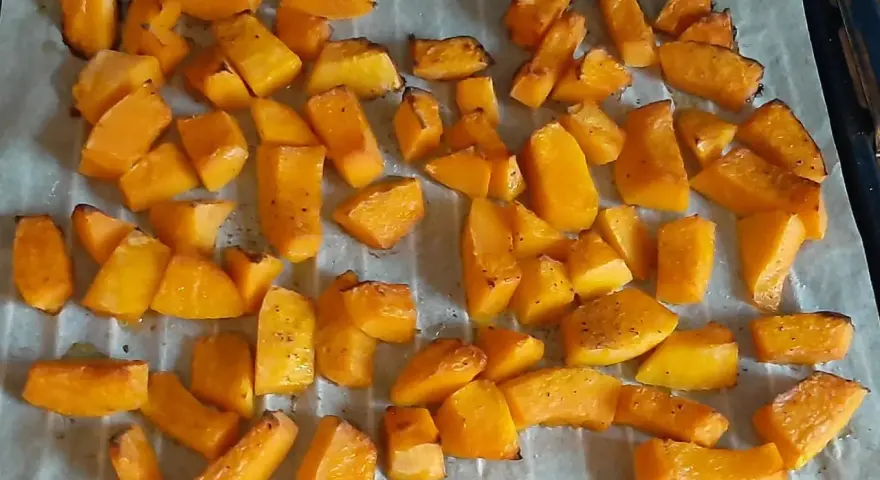Des morceaux de potimarron au four, dorés et légèrement caramélisés, prêts à être dégustés.