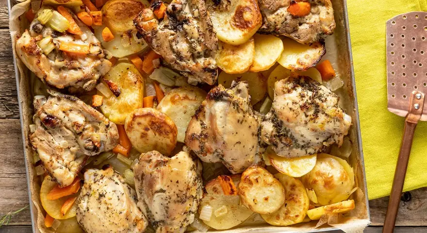 Sovracosce di pollo dorate e succulente, cotte al forno con patate, carote e sedano. Un piatto rustico e saporito.