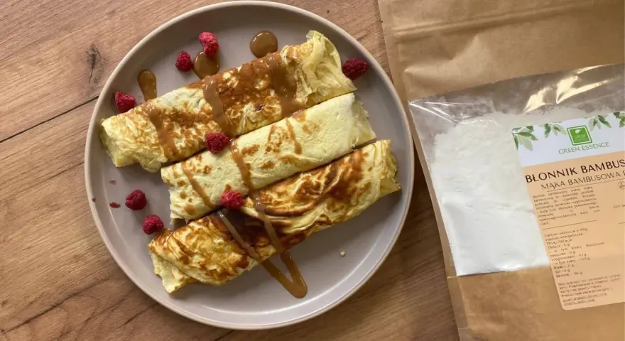 Naleśniki z malinami i syropem, obok paczka mąki bambusowej. Idealne przepisy na zdrowe śniadanie.
