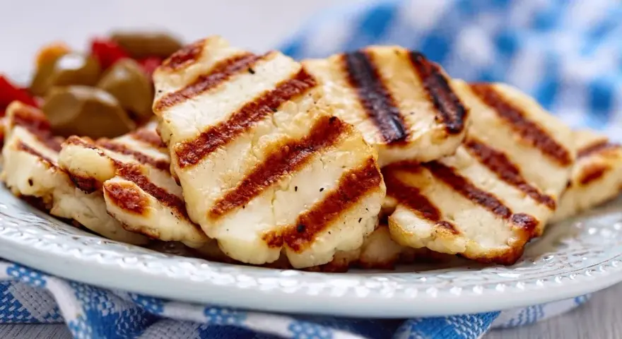 Grillowany ser halloumi na talerzu, z widocznymi paskami z grilla. Idealny dodatek do sałatek, z niską zawartością halloumi kcal.