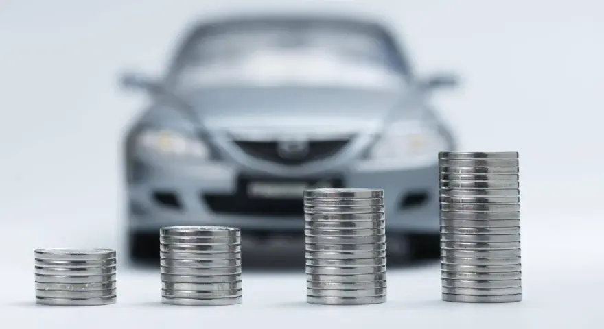 Monete in crescita davanti a un'auto sfocata, simbolo di speranza per l'abolizione superbollo e un futuro più sereno per gli automobilisti.