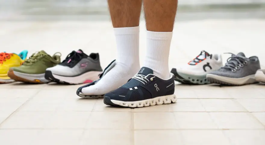 Un hombre prueba varios modelos de zapatillas, buscando el mejor calzado para caminar.