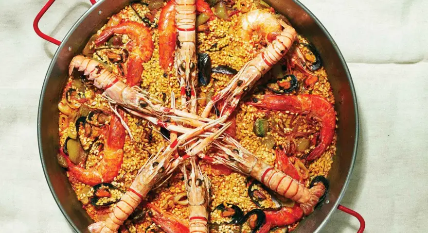 Pyszna paella z owocami morza, ryżem i warzywami. Idealny przepis na paellę dla każdego smakosza.