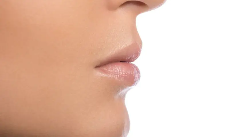 Primer plano de la nariz y los labios de una persona, mostrando la textura de la piel y los filamentos sebáceos en la nariz.