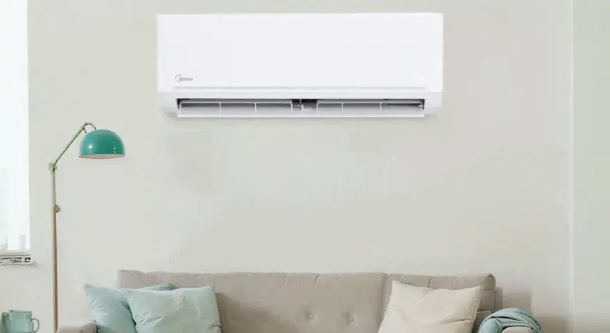 Un aire acondicionado Midea instalado en una pared sobre un sofá. Guía visual para como instalar un aire acondicionado.