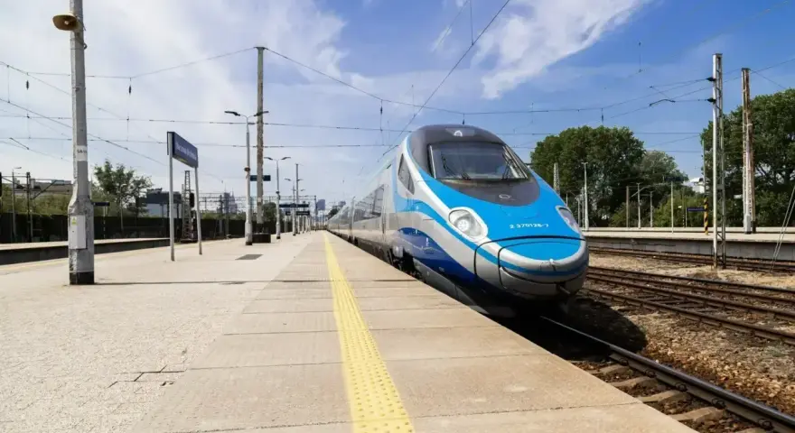 Pendolino na peronie, niebiesko-srebrny pociąg, słoneczny dzień.