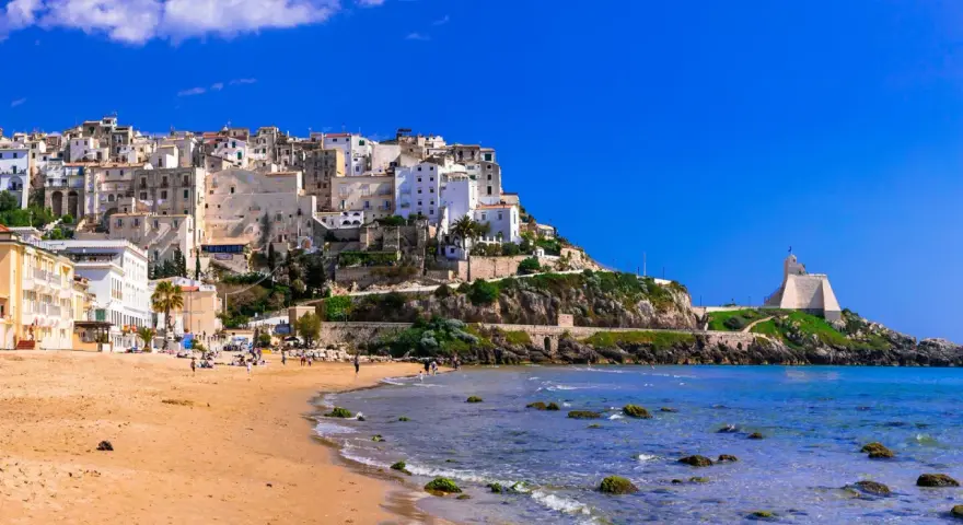 Sperlonga, dove si trova questo incantevole borgo bianco arroccato su una collina, con una spiaggia dorata e il mare azzurro.