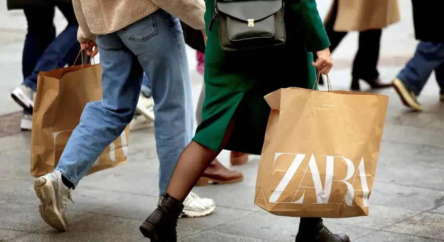 Ludzie idący z torbami ZARA. Może to zakupy, a może zwroty.