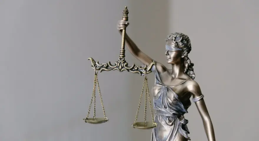 Figurka Temidy z wagą. Czy syndyk sprawdza historię rachunku? Sprawiedliwość waży dowody.