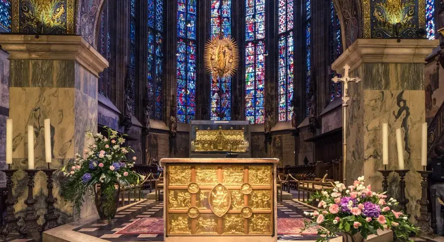 Wnętrze katedry z witrażami, ołtarzem i kwiatami. Jakby śpiewano psalm 98, chwaląc piękno tego miejsca.