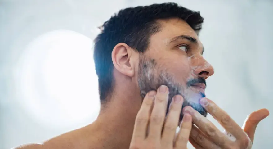 Hombre aplicándose espuma para quitarse la barba.