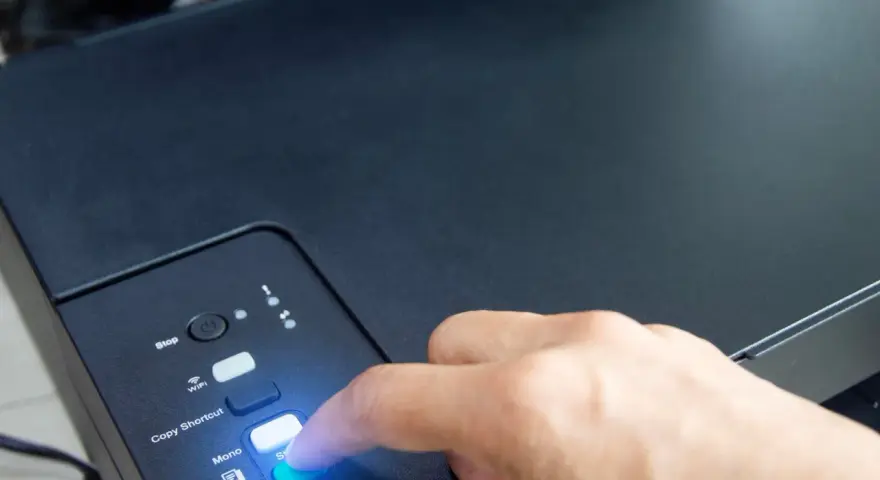 Palec naciska przycisk "Colour" na drukarce HP, rozpoczynając proces, jak podłączyć drukarkę HP do WiFi.