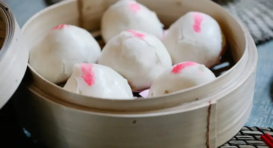 Pierożki baozi w bambusowym parowniku, gotowe do podania.