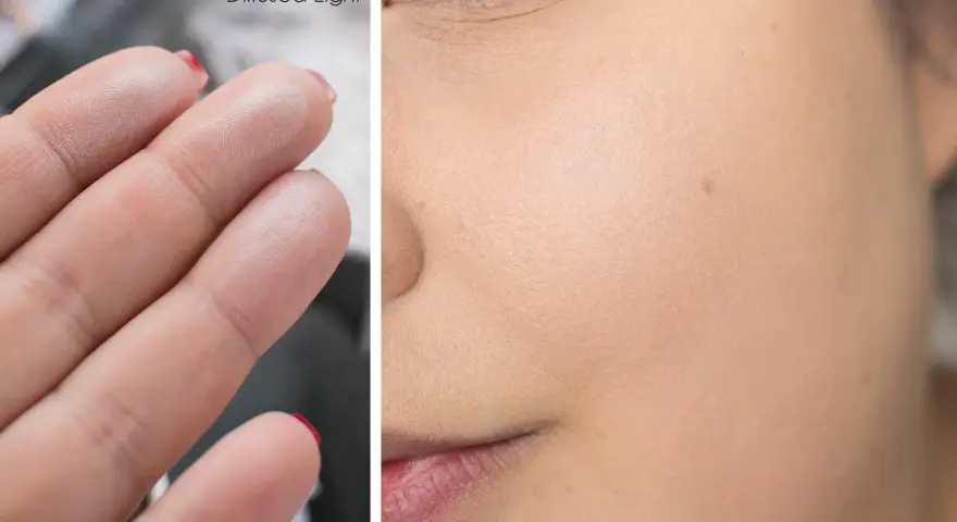 Puder rozświetlający Hourglass Ambient Lighting Powder, Diffused Light na palcach i na skórze twarzy, nadający subtelny blask.