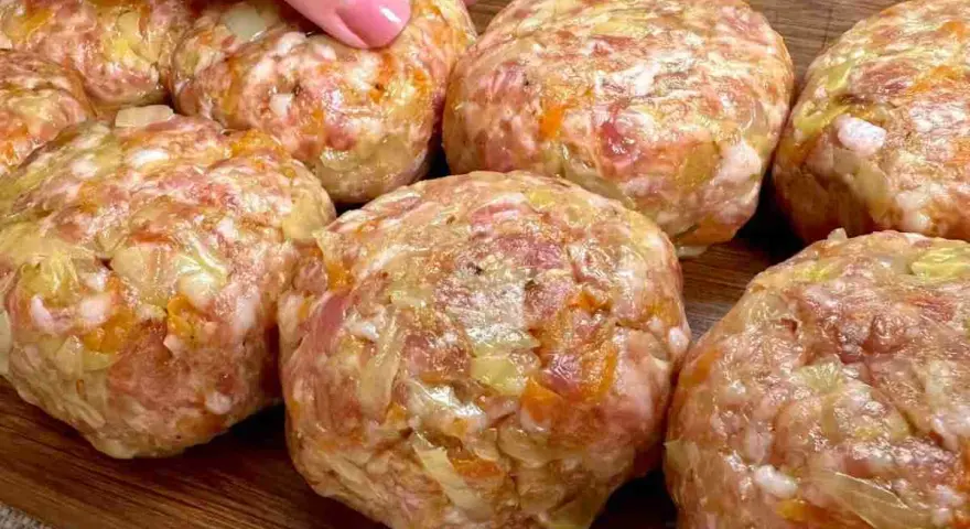 Mani che preparano polpette in bianco, un impasto di carne macinata con verdure, pronte per essere cucinate.