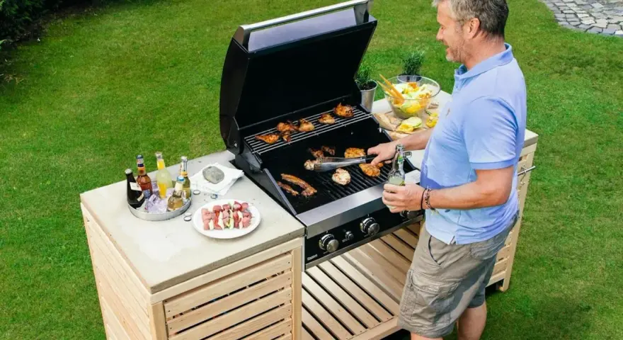 Man grillar på ett fint grillbord i trä. Perfekt för att bygga ett eget grillbord för sommarens fester.
