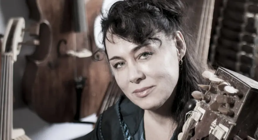 Maria Pomianowska z fidelą i instrumentami smyczkowymi w tle.