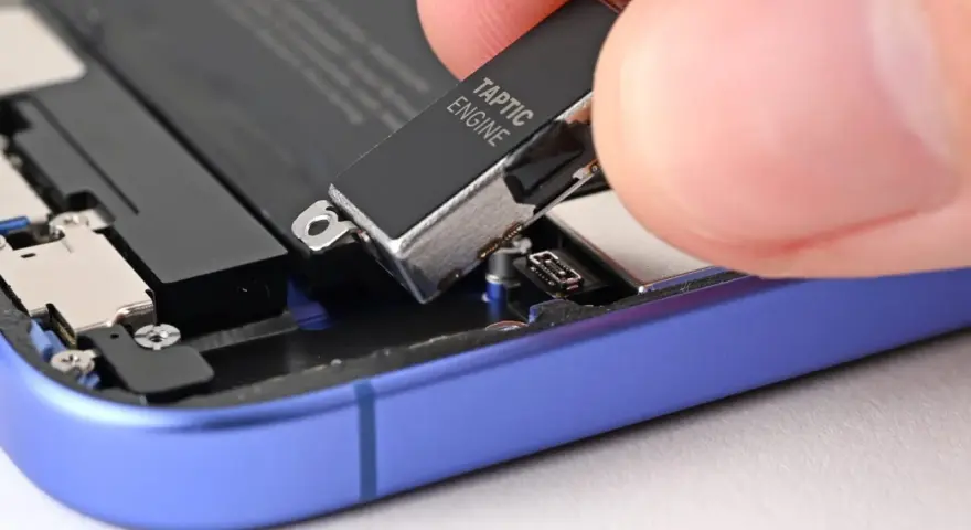 Dłoń wyjmuje moduł Taptic Engine z wnętrza telefonu, element odpowiedzialny za zaawansowane wibracje i 3D Touch.