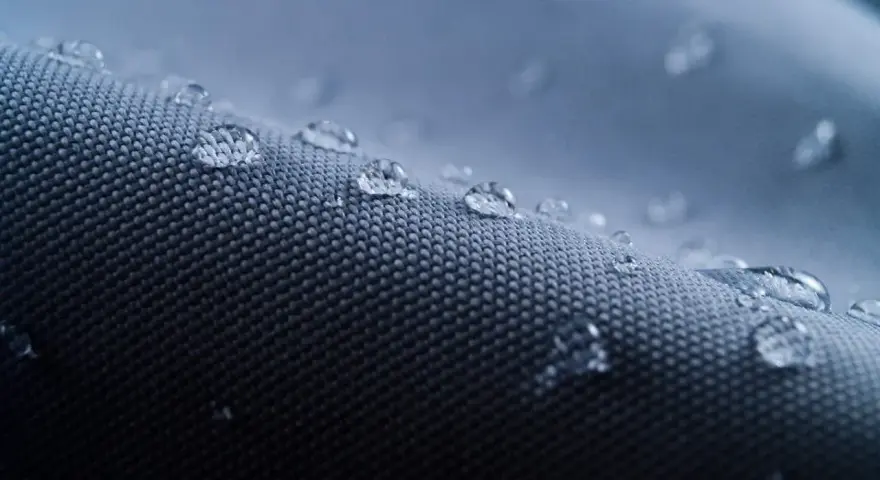 Krople wody na tkaninie. To właśnie nylon, materiał, który nie przepuszcza wilgoci.
