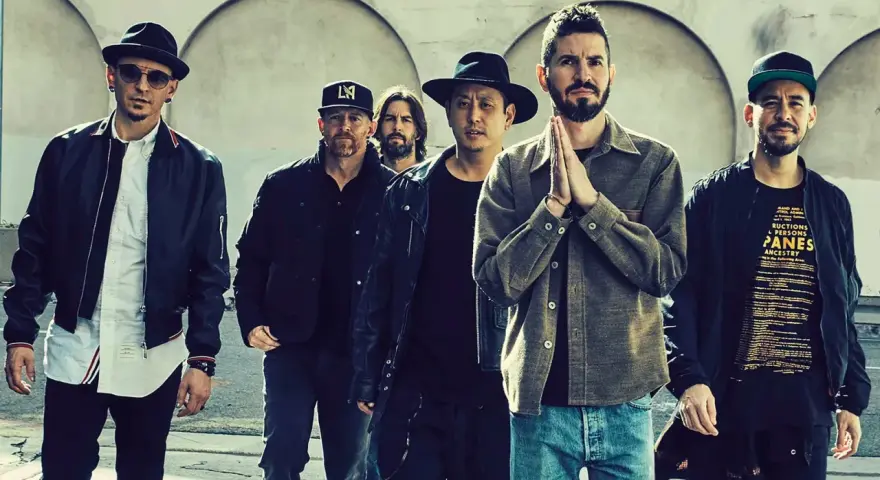 Sechs Männer der Band Linkin Park stehen nebeneinander, einige tragen Hüte und Jacken.