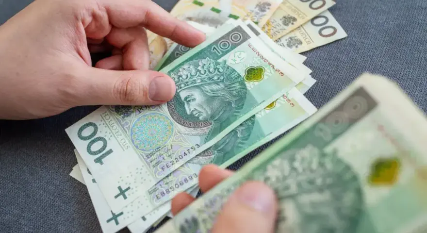 Dłonie liczą polskie banknoty 100 zł. Temat: zespół Aspergera a renta socjalna.