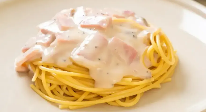 Pyszne spaghetti z kremowym sosem, kawałkami szynki i pieprzem. Idealne makaron po toskańsku na szybki obiad.