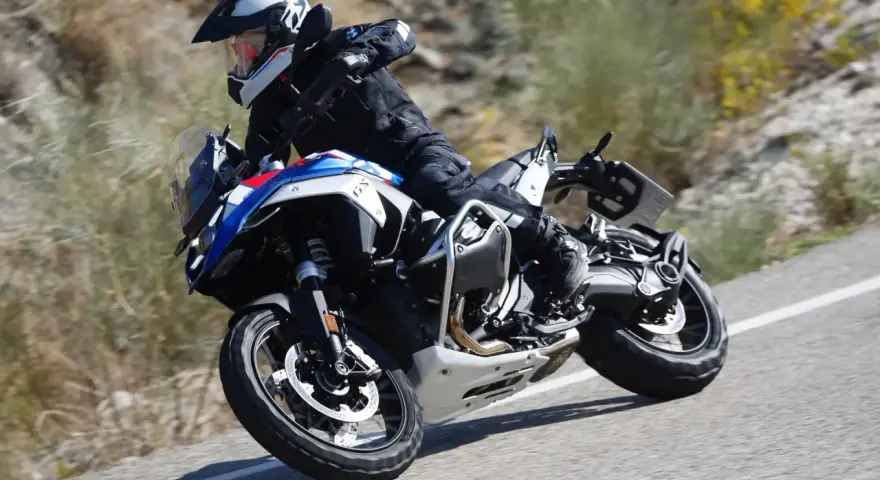 Motociclista in sella a una BMW GS 1300, che affronta una curva su strada sterrata, sfiorando la velocità massima.