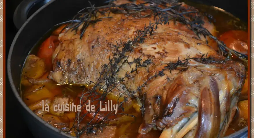 Épaule d'agneau rôtie dans un plat avec des herbes et des légumes.
