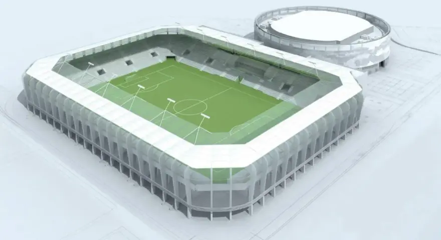 Nowoczesny stadion RKS Radomiak Radom z zieloną murawą i trybunami. Obok okrągły budynek.