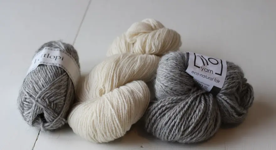 Mjuka garnnystan i grått och naturvitt. Perfekt ullgarn som inte kliar, redo att bli ditt nästa stickprojekt.