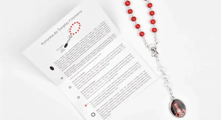 Modlitwa do św. Ekspedyta o szybką pomoc. Czerwona koronka z medalikiem Matki Bożej i instrukcją modlitwy.