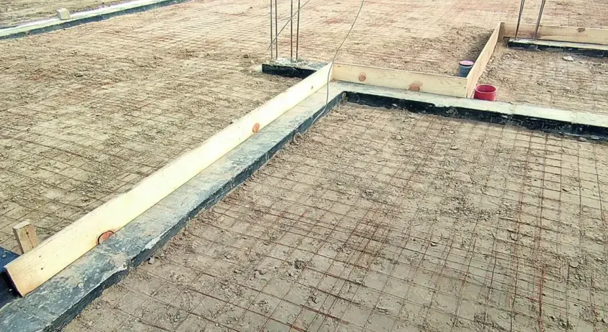 Przygotowanie pod fundamenty: siatka zbrojeniowa i szalunki czekają na odpowiedni beton na chudziaka.