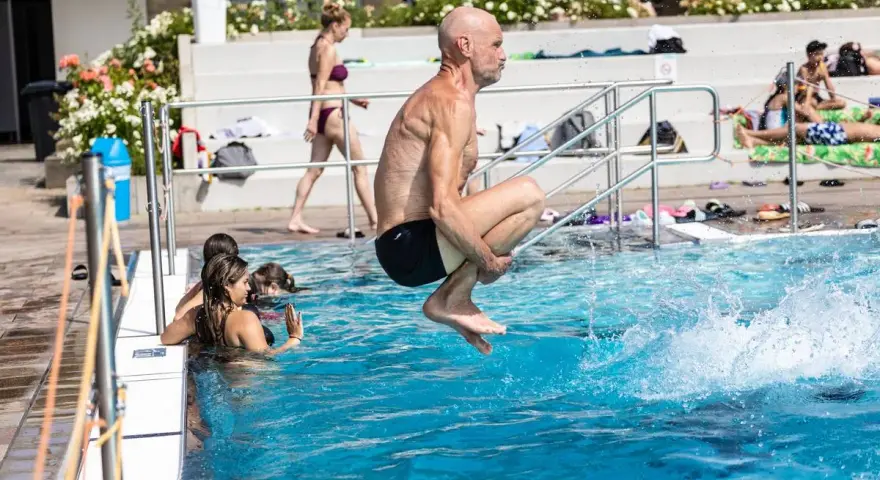 Mann springt ins Wasser, um Thrombose vorzubeugen. Schwimmen ist gut für die Durchblutung.