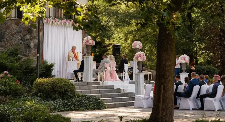 Piękna ceremonia ślubna w plenerze. Czy ksiądz może udzielić ślubu w plenerze? Tak, jak widać na zdjęciu, gdzie młoda para ślubuje sobie miłość przed ołtarzem na świeżym powietrzu.