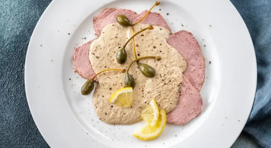 Dünne Scheiben Kalbfleisch mit cremiger Thunfischsauce, Kapern und Zitronenspalten – das beste Vitello Tonnato Rezept für einen Genussmoment.