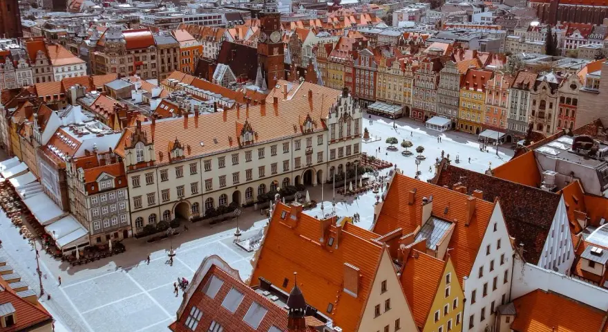 Widok z góry na Rynek we Wrocławiu z kolorowymi kamienicami i ratuszem.